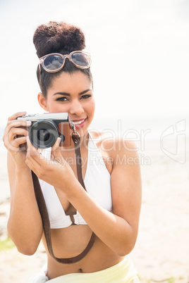 Pretty hipster in bikini taking picture