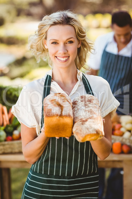 Smiling farmer woman holding breads