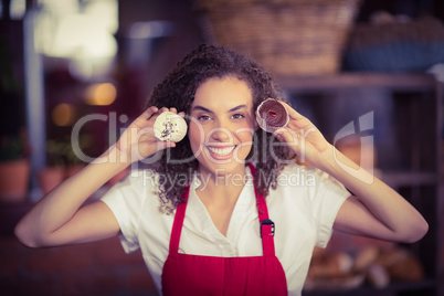 Smiling waitress showing two cupcakes