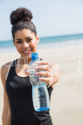 Fit woman showing water bottle