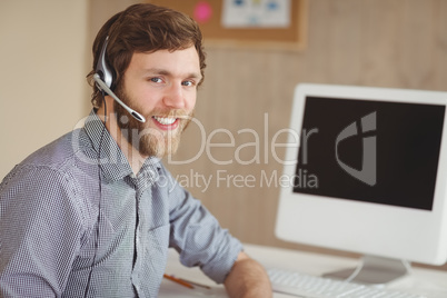 Bearded hipster at desk with headset