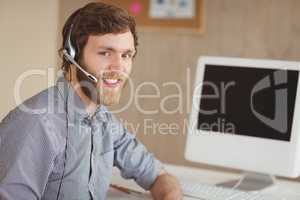 Bearded hipster at desk with headset