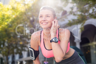 A beautiful athlete putting her headphones