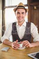 Smiling hipster with cup of coffee