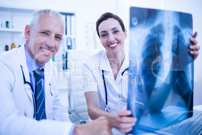 Portrait of smiling medical colleagues holding x-ray