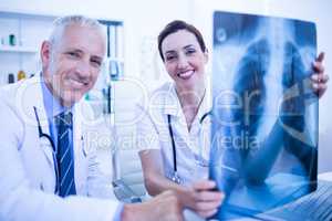 Portrait of smiling medical colleagues holding x-ray