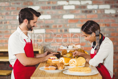 Waiters tidying up pastries on the counter