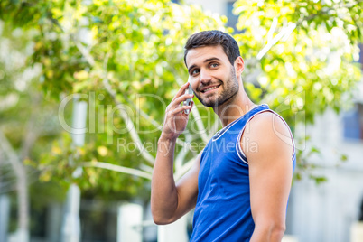 An happy handsome athlete calling