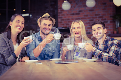 Smiling friends enjoying coffee together