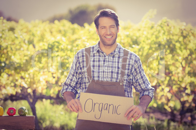 Smiling farmer holding an organic sign