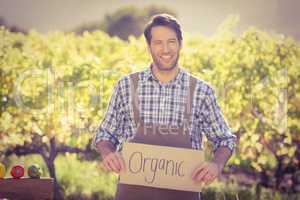 Smiling farmer holding an organic sign