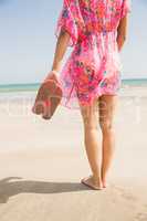 Stylish woman standing on the sand