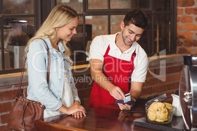 Smiling waiter swiping the credit card