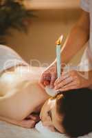 Young woman getting ear candling treatment