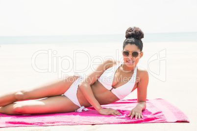 Smiling woman sunbathing on towel