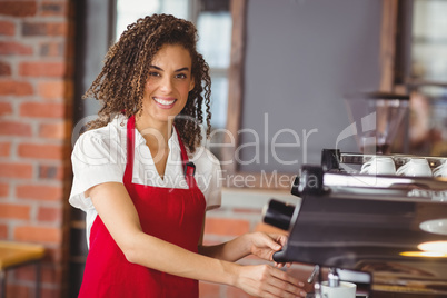 A smiling barista preparing coffee