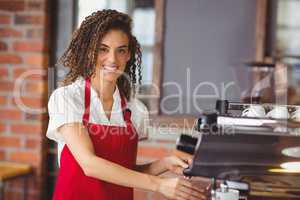 A smiling barista preparing coffee