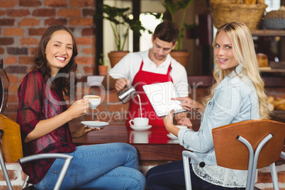 Handsome waiter preparing a cup of coffee