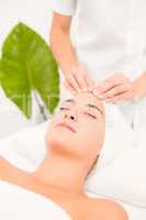 Attractive woman receiving facial massage at spa center