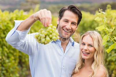 Young happy couple looking at grapes