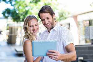 Smiling couple using tablet computer