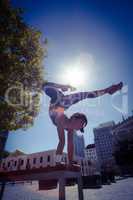 Athletic woman performing handstand on bench