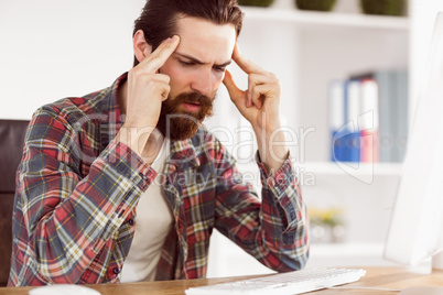 Hipster businessman stressed at his desk Hipster businessman stressed at his desk