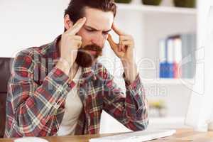 Hipster businessman stressed at his desk