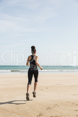 Fit woman jogging on the sand Fit woman jogging on the sand