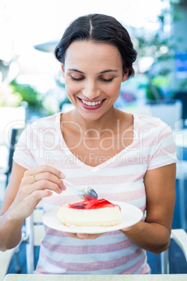 Smiling brunette taking a piece of chocolate cake