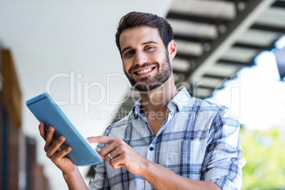 Hipster man using tablet computer in the city