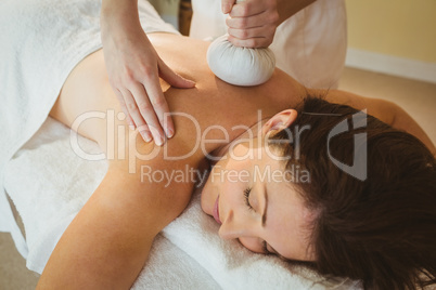 Young woman getting herbal compress massage