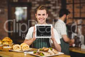 Smiling waiter holding a digital tablet