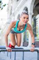 A beautiful woman stretching her body against pipes