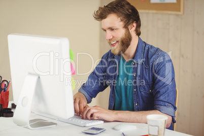 Happy hipster working at his desk