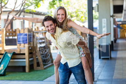 Smiling woman piggy-backing on her boyfriend