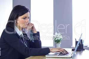 Businesswoman working on laptop at her desk