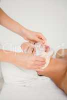 Hand cleaning womans face with cotton swabs with side view
