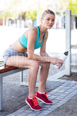 A beautiful woman sitting and holding a bottle
