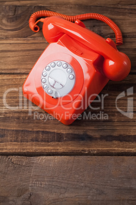 Red telephone on wooden table