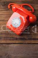 Red telephone on wooden table