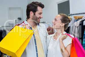 Smiling couple with shopping bags looking at each other