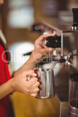 Barista steaming milk at the coffee machine