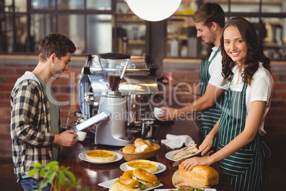 Smiling waiters serving a client