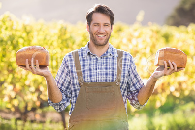 Smiling farmer holding two tasty breads