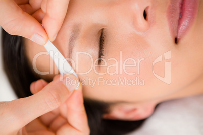 Hand waxing beautiful womans eyebrow