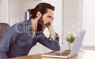 Hipster businessman working on laptop