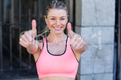 Portrait of a beautiful athlete with thumbs up