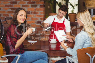 Handsome waiter preparing a cup of coffee