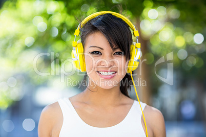 Portrait of smiling athletic woman wearing yellow headphones